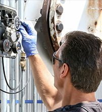 a man with gloves and security glasses on working