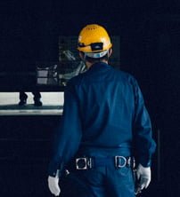 a worker in blue uniform with yellow security helmet